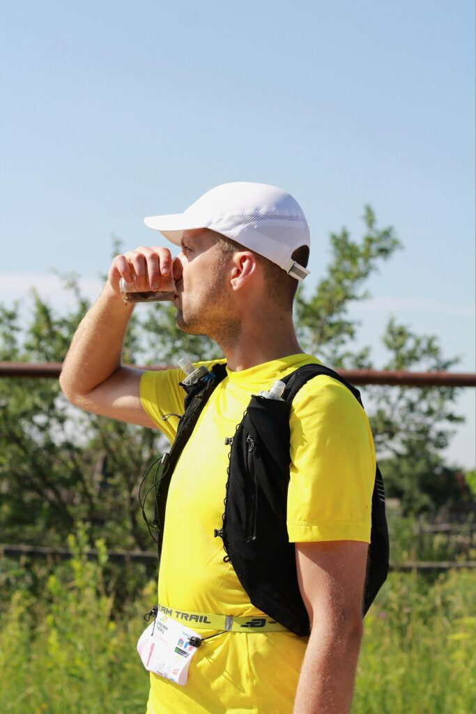 uomo con gilet da trail running si idrata
